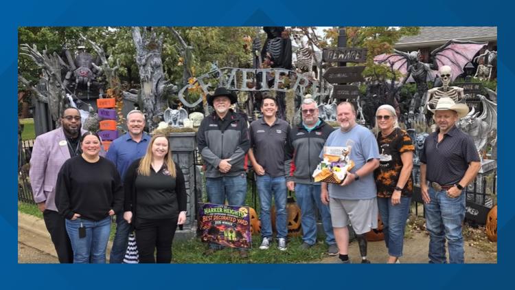 A spooky Halloween display featuring tombstones and skeletons in a yard